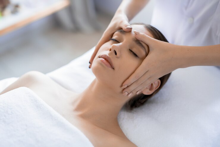 A woman getting facial and head massage.